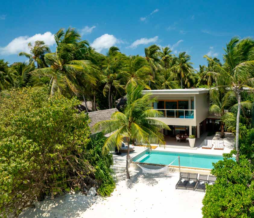 An exterior view of the freshwater pool and beach hammock at our private beachfront Family Residences and Villas.