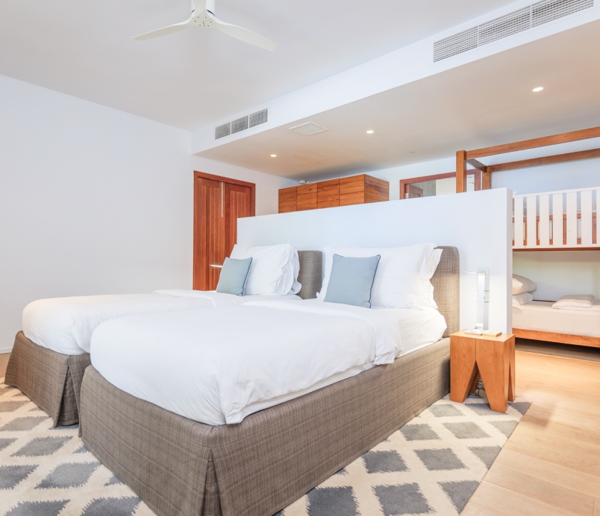 A bedroom with 3 single beds of the bedrooms inside of our 2 bedroom villas with pool.