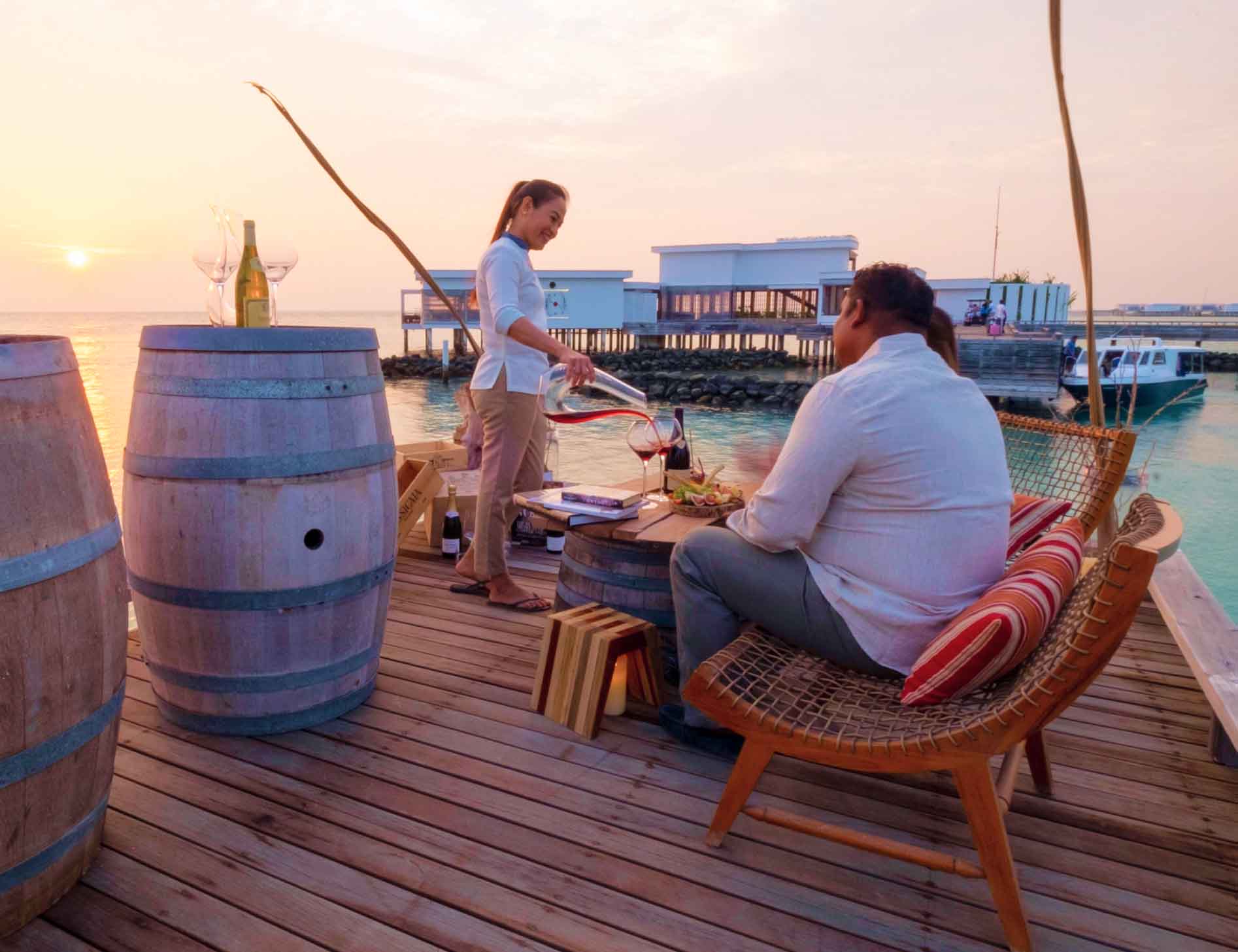 Amilla Team relaxing on a dock, enjoying their jobs in the Maldives.